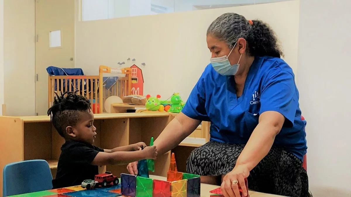 Fidelina with a Child Playing with Magnetic Tiles